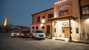 A building with the sign "Arkanchi" and three parked cars in front. - Arkanchi Hotel (Khiva)