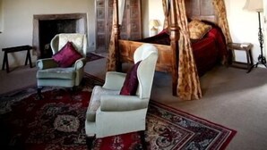 A traditional room with a four-poster bed, a fireplace, and a large rug. - Blackmore Farm (Bridgwater)