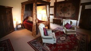 A traditional room with a four-poster bed, two armchairs, and a large patterned rug. - Blackmore Farm (Bridgwater)