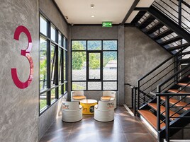 Un interior moderno con un gran número 3 en la pared, una escalera y zonas de estar con la marca 'ONE LOFT'.