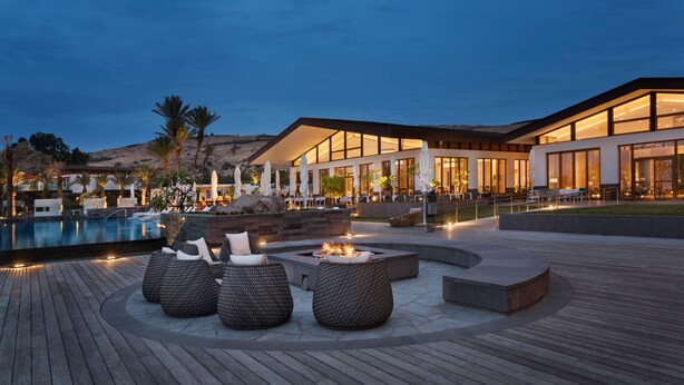 A modern resort with a pool, outdoor seating, and a well-lit building. - The Setai Sea of Galilee (Ramot)