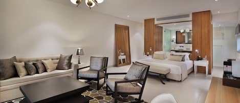 Une chambre d’hôtel moderne équipée d’un canapé, de fauteuils, d’une table basse, d’un lit, d’un bureau et d’un miroir.