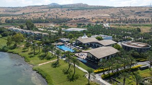 A resort with multiple buildings, a swimming pool, and a river. - The Setai Sea of Galilee (Ramot)