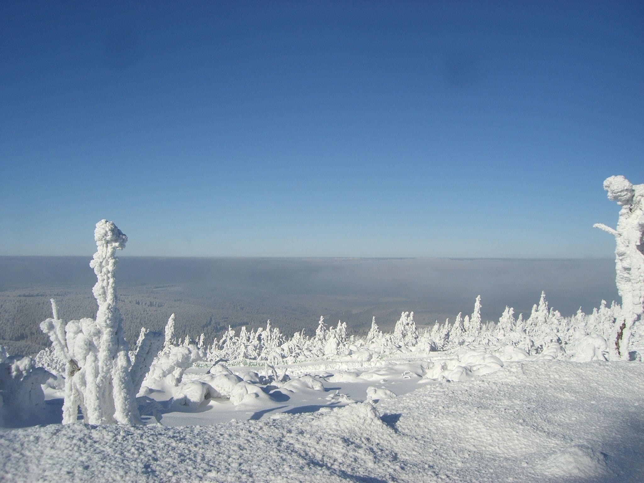 Eine verschneite Landschaft mit blauem Himmel.