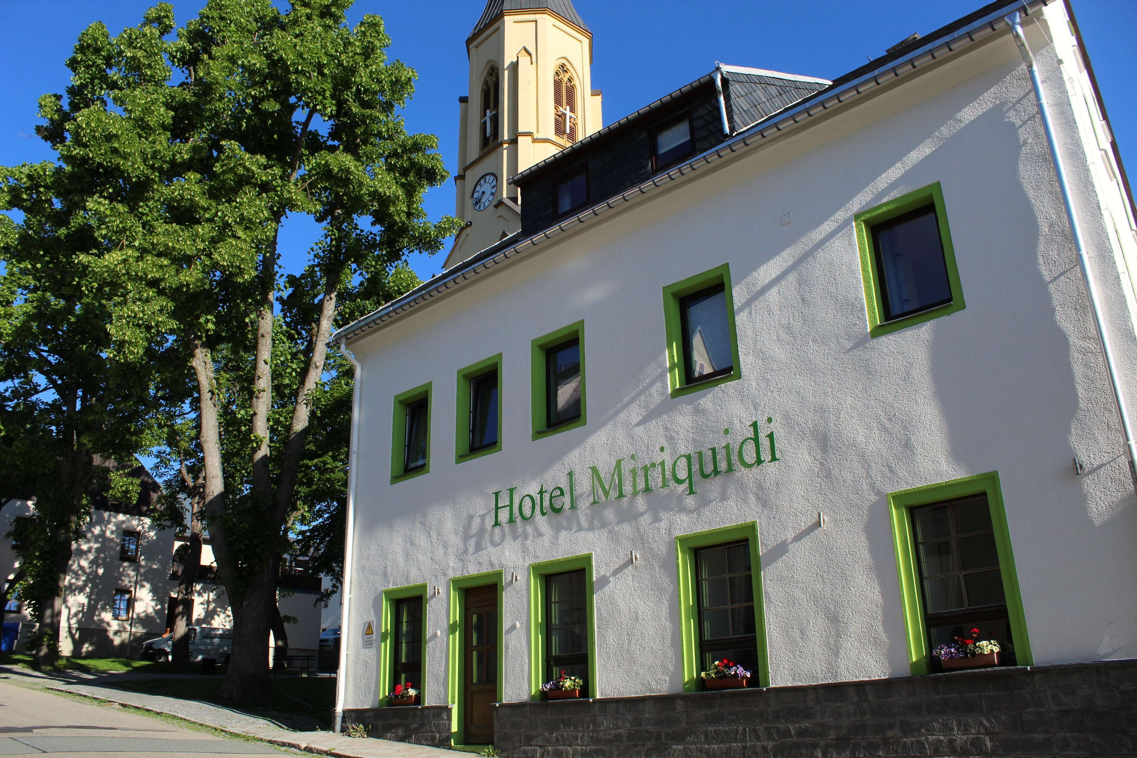 A building with the sign "Hotel Miriquidi" and a clock tower.