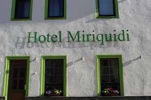 The exterior of Hotel Miriquidi with green-framed windows and a sign above them. - Hotel Miriquidi (Oberwiesenthal)