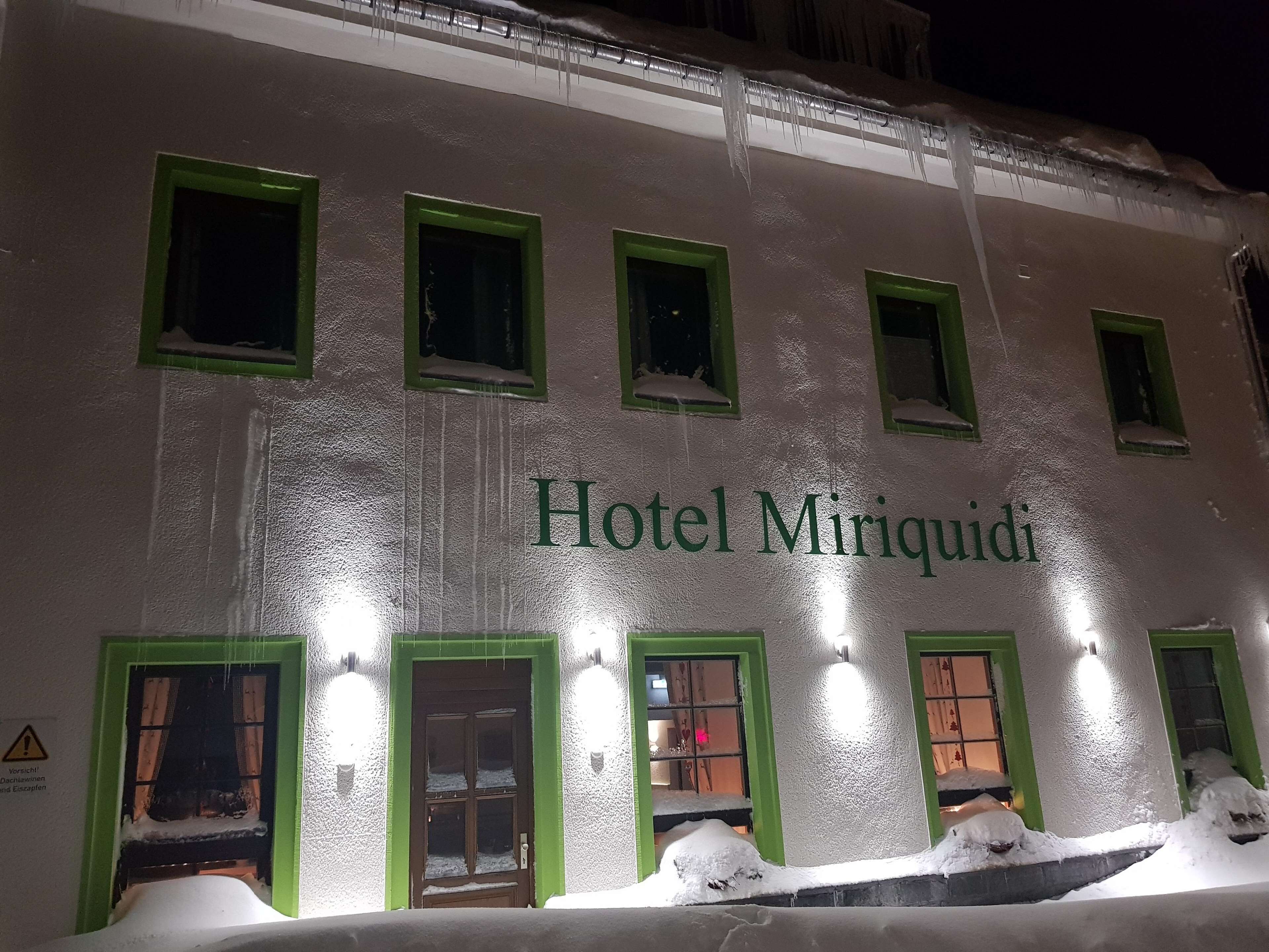 Hotel Miriquidi met meerdere ramen en deuren, waarvan sommige bedekt zijn met sneeuw.