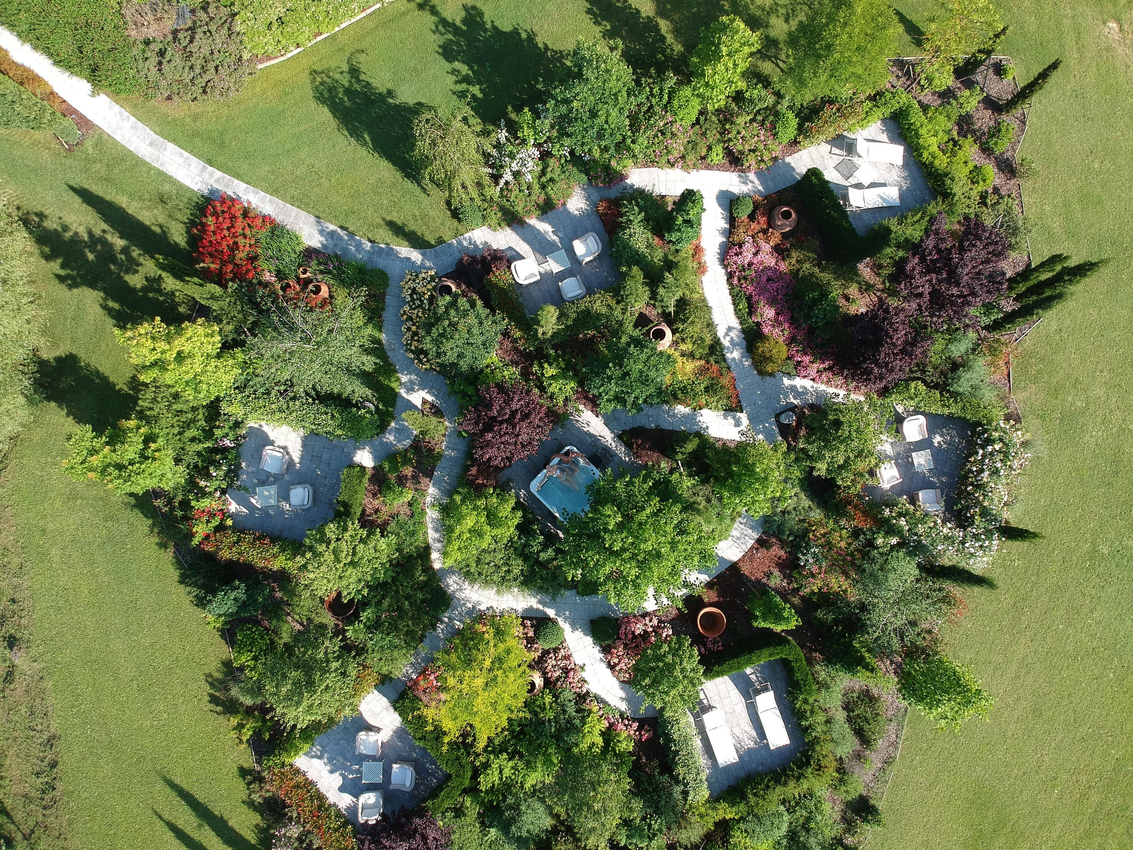 Vista aérea de uma área residencial com várias casas, um espaço pavimentado central e áreas verdes ao redor.