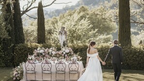 A wedding reception table set outdoors with floral arrangements and candles. - Relais Sassa al Sole (San Miniato)