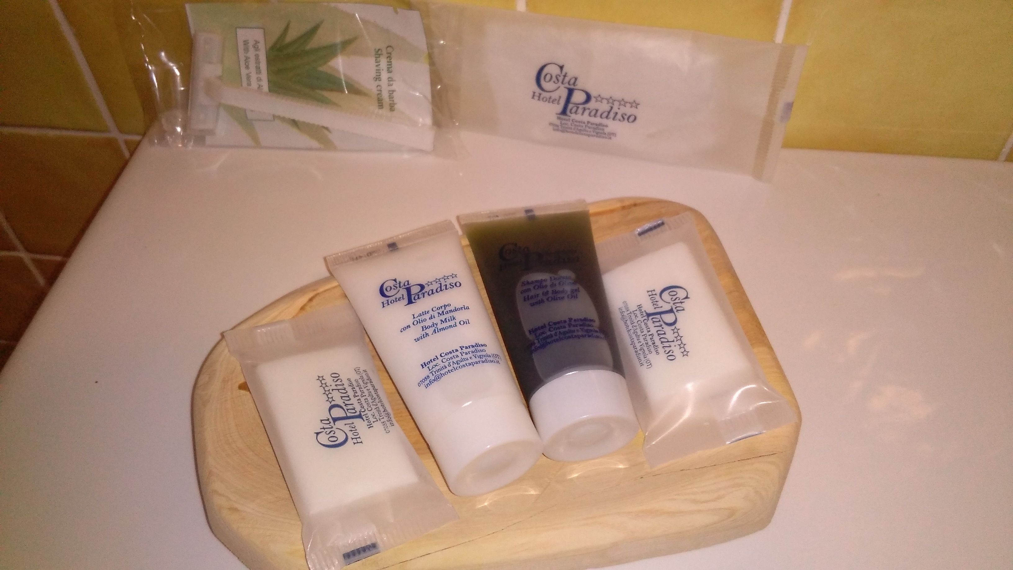 A wooden tray with various Costa Paradiso Hotel Costa Paradiso toiletries on a bathroom counter.