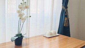 A wooden table with a potted orchid and two white teacups on a tray. - Novella Italy (Florence)