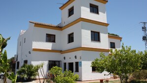 Um edifício de dois andares com fachada branca e detalhes em amarelo.