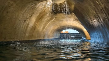 Una piscina al aire libre, sombrillas, sillones reclinables de piscina