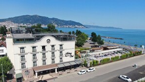 Un hôtel offrant une vue sur la mer et les montagnes, doté d’un design moderne et d’une terrasse sur le toit.