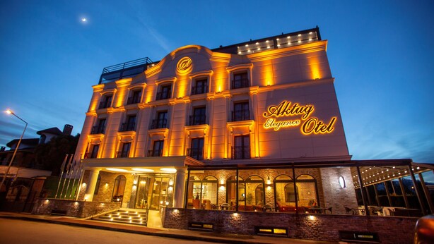 Un hôtel à la façade classique, doté de grandes fenêtres et d’une entrée imposante, accessible par un escalier.