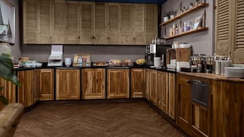 Une cuisine avec des meubles de rangement en bois, un parquet en point de Hongrie et divers aliments pour le petit-déjeuner disposés sur le comptoir.