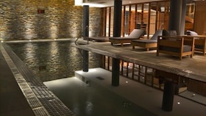 Un espace spa agrémenté d’un mur en pierre, d’une piscine et de sièges.