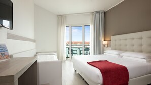 Una habitación de hotel con cama, escritorio y vistas al exterior.
