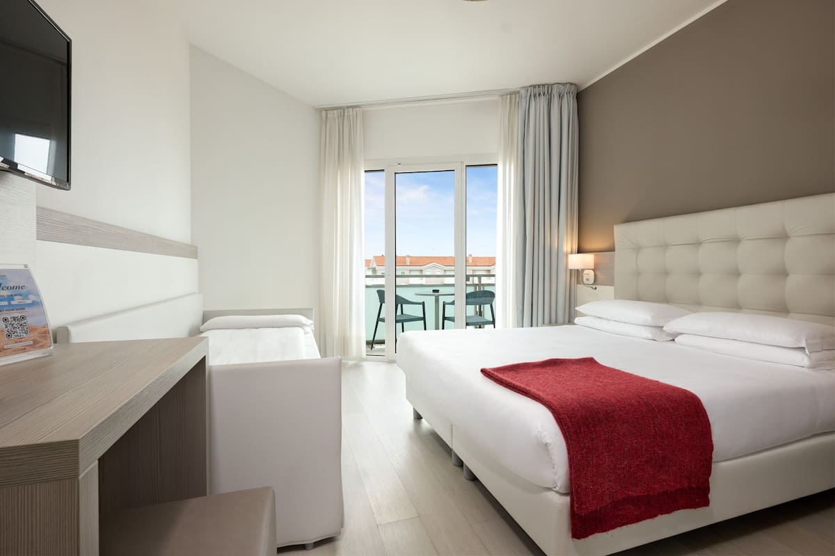 Una habitación de hotel con cama, escritorio y vistas al exterior.