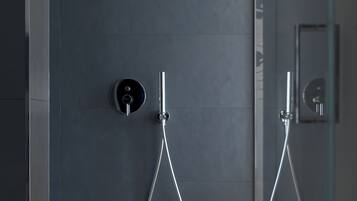 A modern shower enclosure with a glass door and a control panel on the wall.