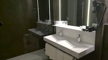 Un baño moderno con dos lavamanos, un espejo grande y un secador de pelo en la pared.