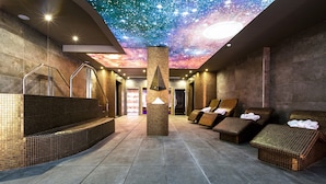 A spa area with a starry ceiling, a central pillar, and wicker seating.