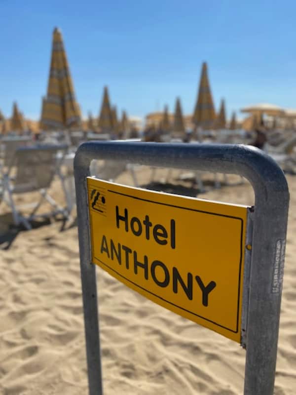 Aan een privƩstrand, wit zand, ligstoelen, parasols