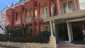 A multi-story hotel with balconies, a brick facade, and a tiled entrance area. - Hotel Paradise (Kemer)