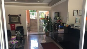 A modern interior with a dining area, a reception desk, and a staircase leading to an outdoor area. - Hotel Paradise (Kemer)