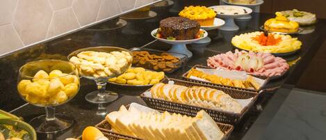 A buffet with various food items and a hexagonal tiled wall.