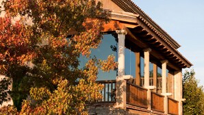 A stone building with a wooden balcony and columns.