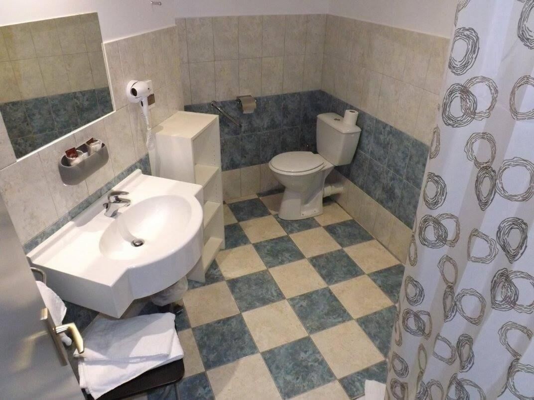 Un baño con lavabo, inodoro y cortina de ducha.