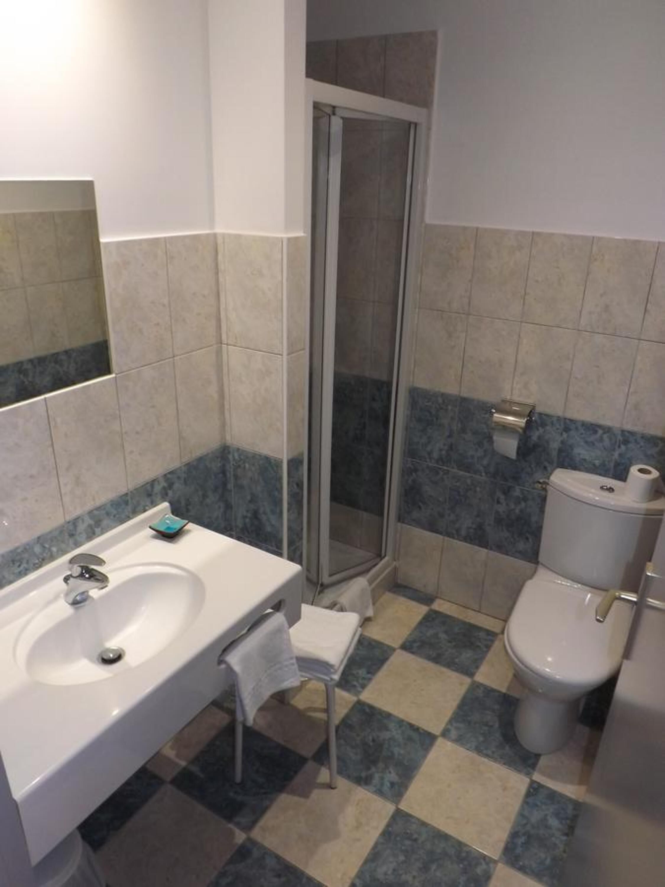 A bathroom with a sink, toilet, and shower.