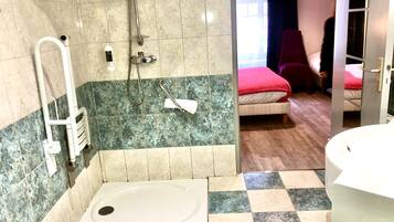 A bathroom with a shower, a bathtub, and a toilet.