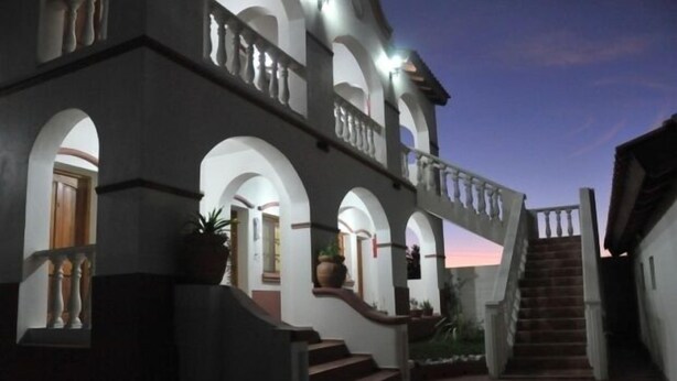 Un edificio de varios pisos con una escalera central, ventanas de arco y un balcón.