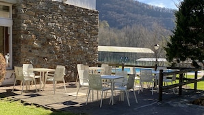 A stone building with outdoor seating and a pool. - Hotel Solana del Ter (Ripoll)