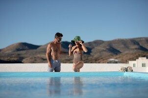 Una piscina al aire libre de temporada, sombrillas, tumbonas