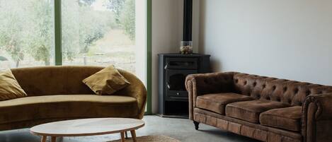 A modern living room with a sofa, a coffee table, and a fireplace.