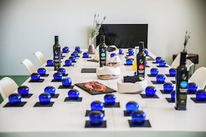 Ein Konferenzraum mit einem langen Tisch, blauen Glasdekorationen und Getränkeflaschen.