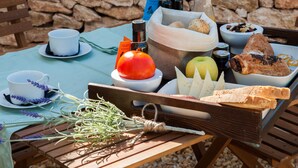 Une table dressée pour un pique-nique, avec de la nourriture, une bouteille et une tasse.