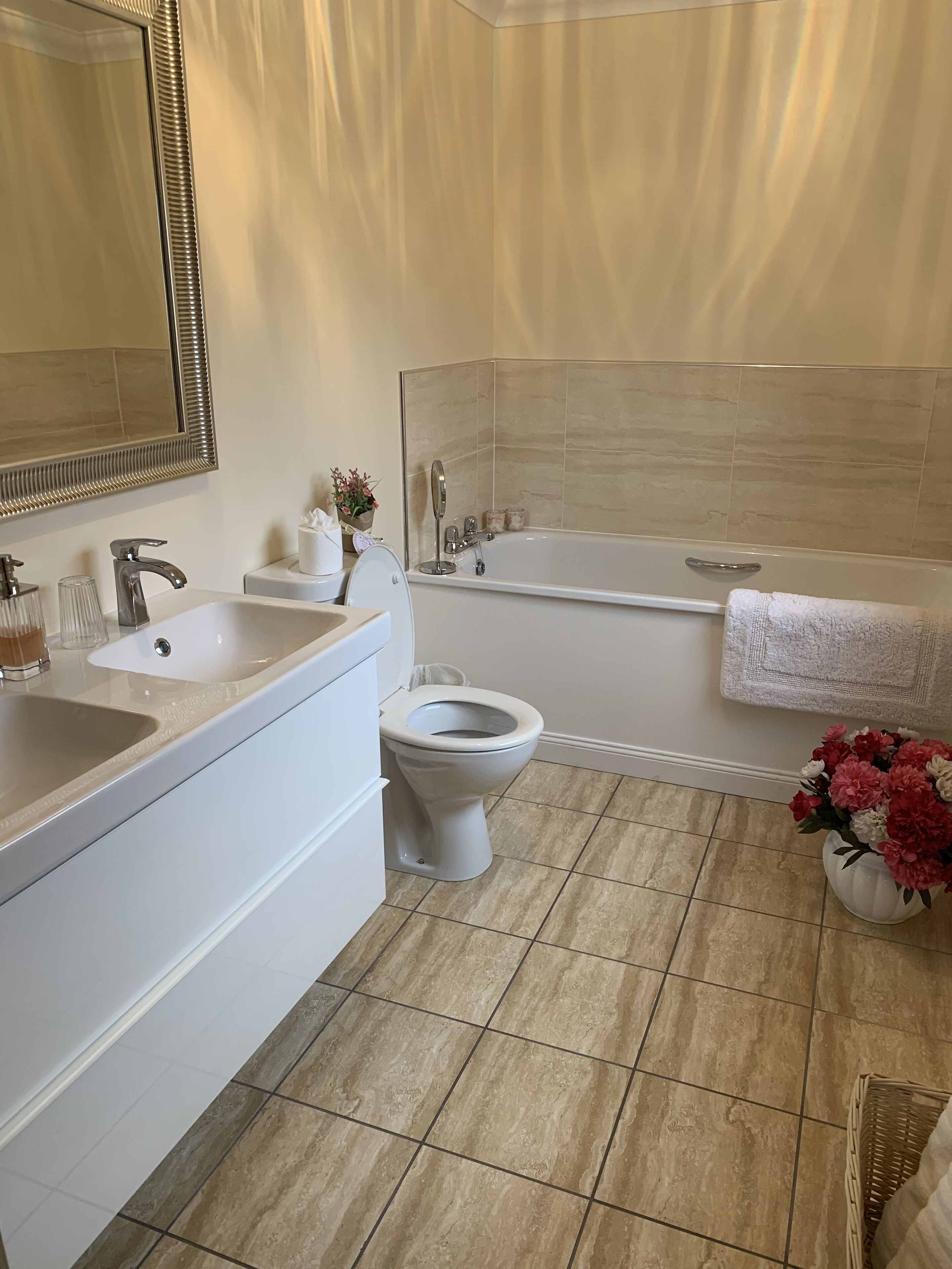 A modern bathroom with a sink, toilet, and bathtub.