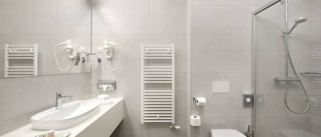 A modern bathroom with a large sink, toilet, and shower.
