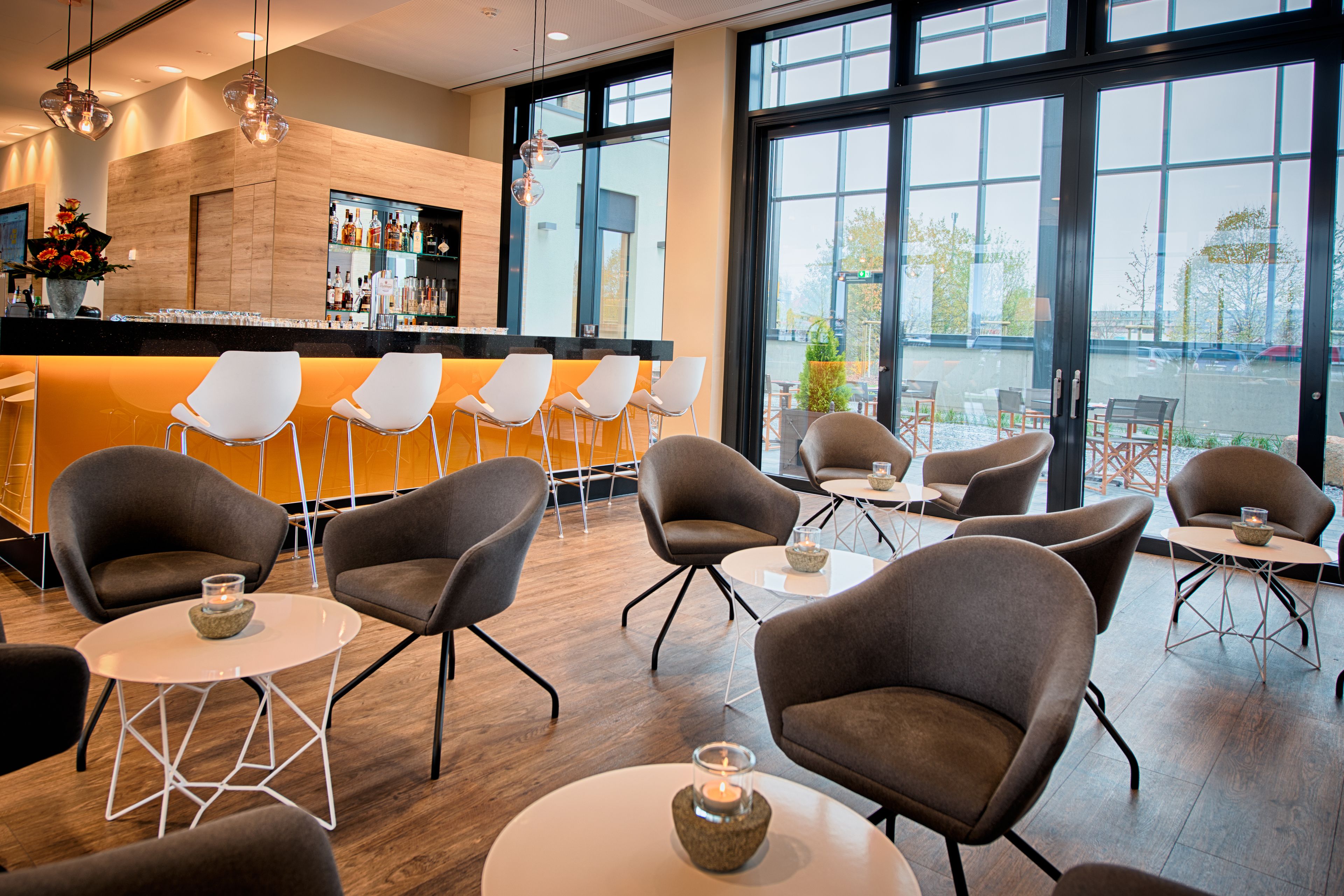 A modern bar area with seating and large windows.