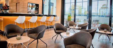 A modern bar area with seating and large windows.