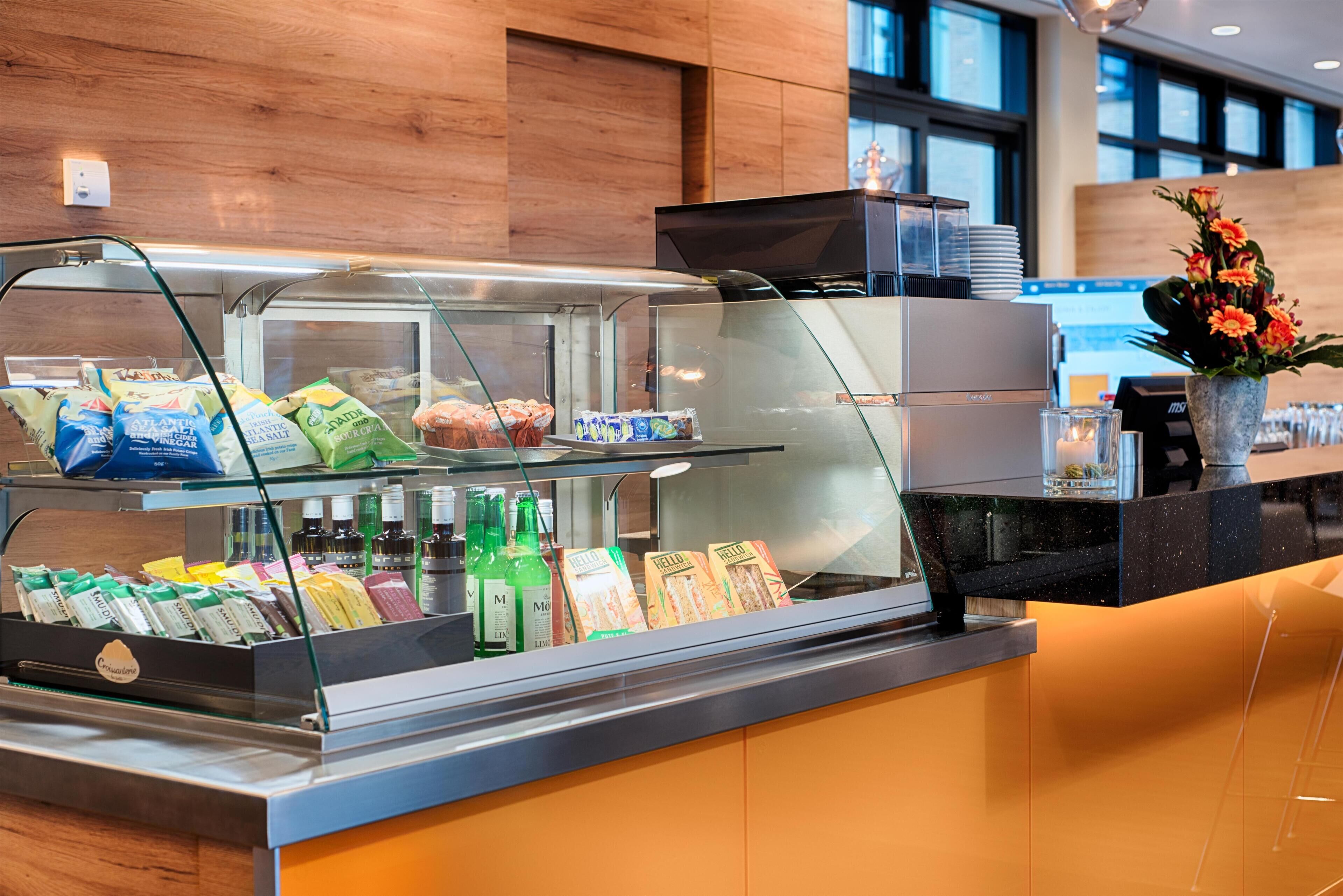 A self-service breakfast station with various food items and beverages.