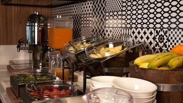 A buffet with various food items and a coffee machine.