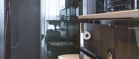 Un baño moderno con ducha acristalada, inodoro y lavamanos.