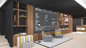 Una moderna hall d'albergo con un grande schermo digitale che mostra destinazioni di viaggio e orari, scaffali in legno con libri e oggetti decorativi, e un'accogliente area salotto con poltrone a fantasia.
