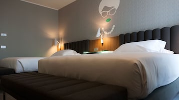 Habitación de hotel con dos camas, un banco y una pared decorada con un gráfico.