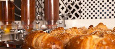 A tray of croissants and three glasses of coffee.
